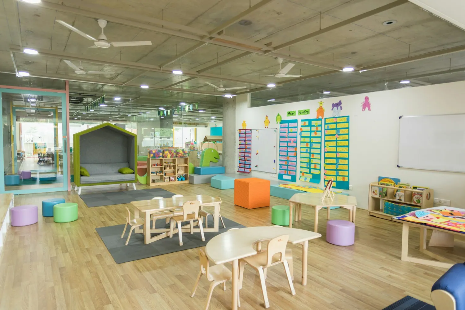 A bright nursery room with low tables and colourful bunting