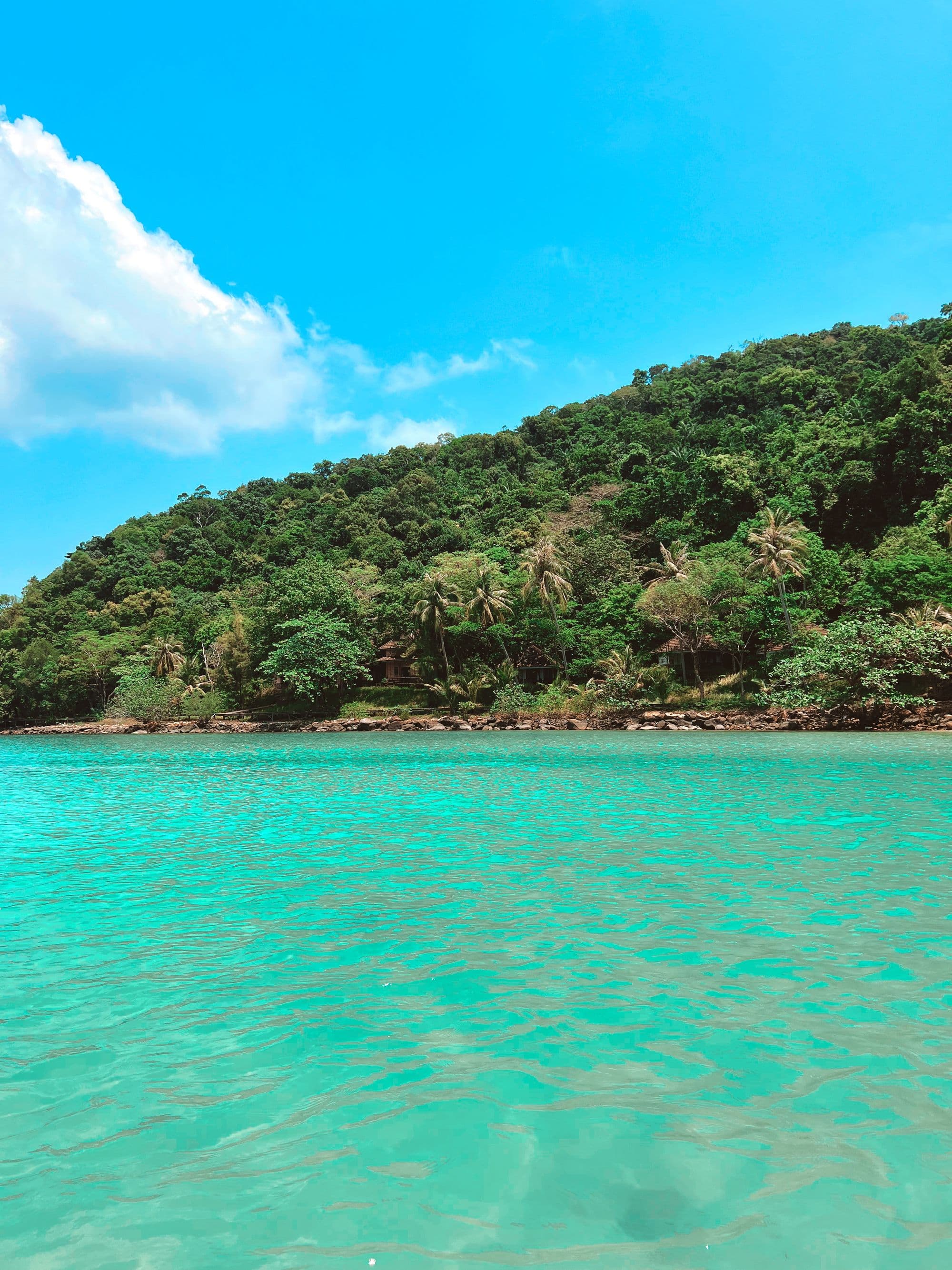 Aerial view of a tropical island fringed by turquoise shallows